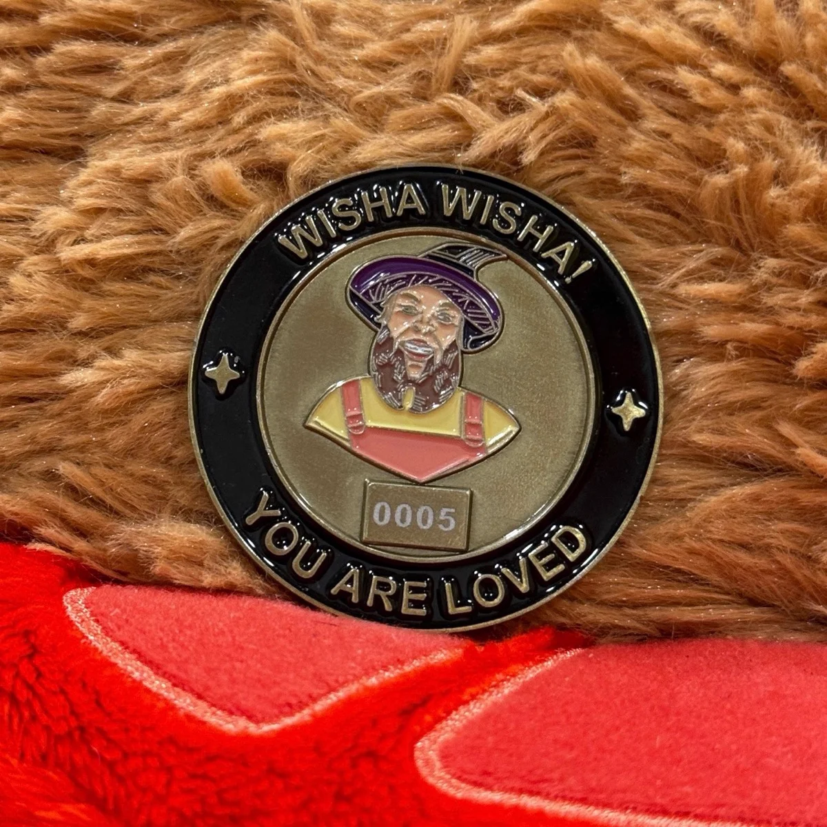 The Wisha Wisha coin resting on a plush teddy bear